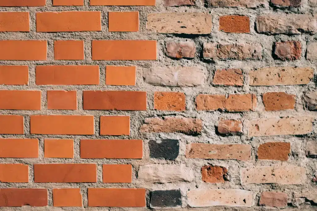 Repointed brickwork showcasing a mix of new and aged bricks, highlighting the importance of seasonal repairs for structural integrity and aesthetic preservation.