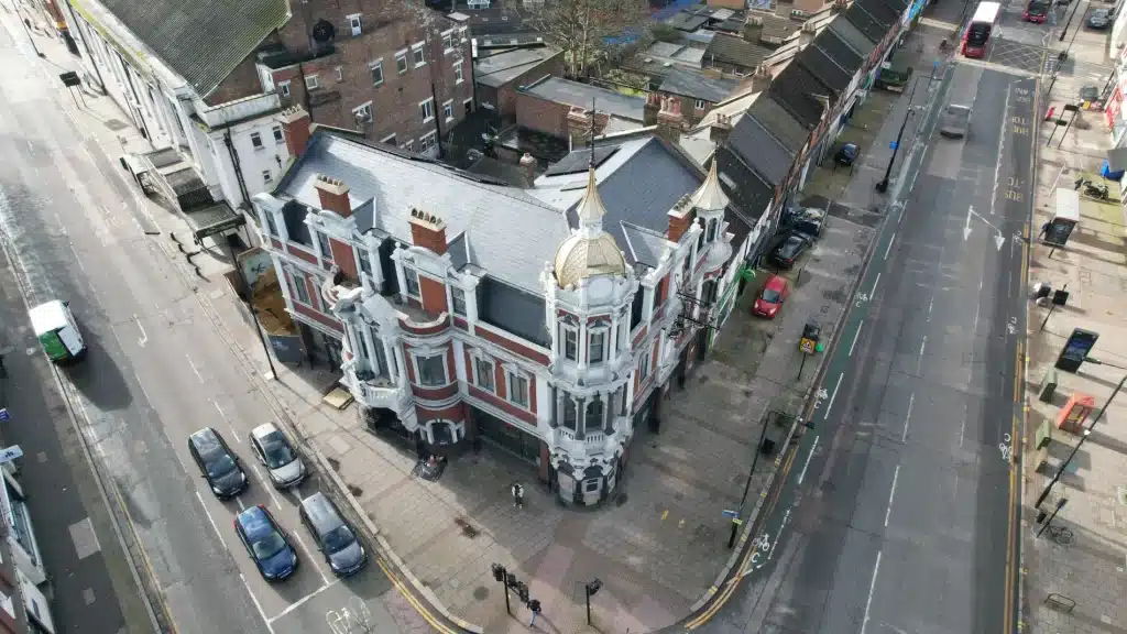 Historic building with intricate architectural features, showcasing well-maintained brickwork, surrounded by urban street scene, illustrating the importance of preserving architectural integrity through professional cleaning services.
