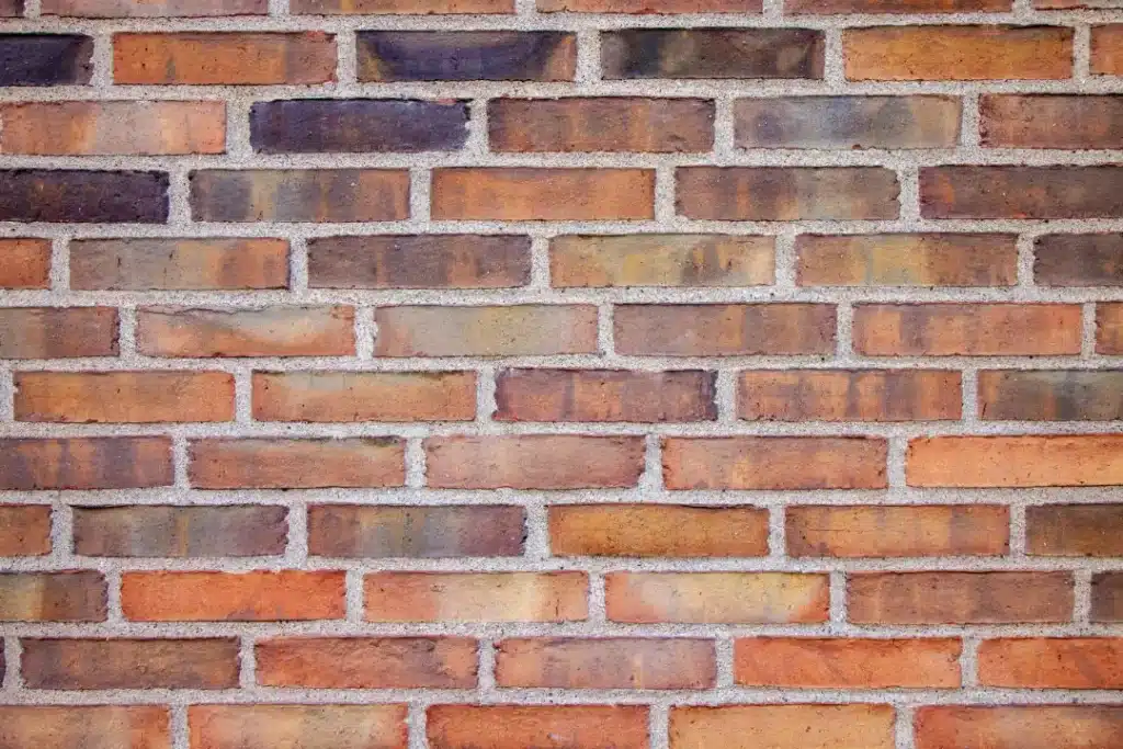 Brick wall featuring various shades of orange and brown, highlighting the importance of professional brick cleaning for maintaining aesthetic appeal and structural integrity.