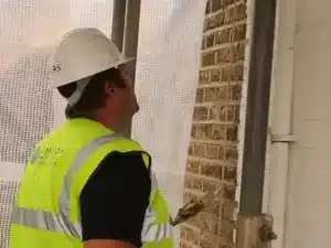 Professional inspecting lime mortar in a historic building, showcasing maintenance tools