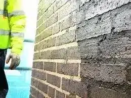 Close up of a wall repair process for penetrating dampness showcasing tools and treatment methods